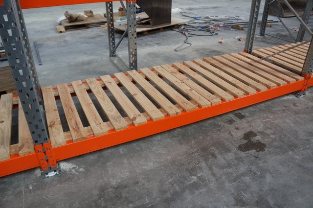 Le platelage sapin pour rayonnages de stockage RSL ressemble à des planches de bois accolées entre elles. Il est mis en présentation sur des lisses de racks afin de voir sa simplicité de pose.