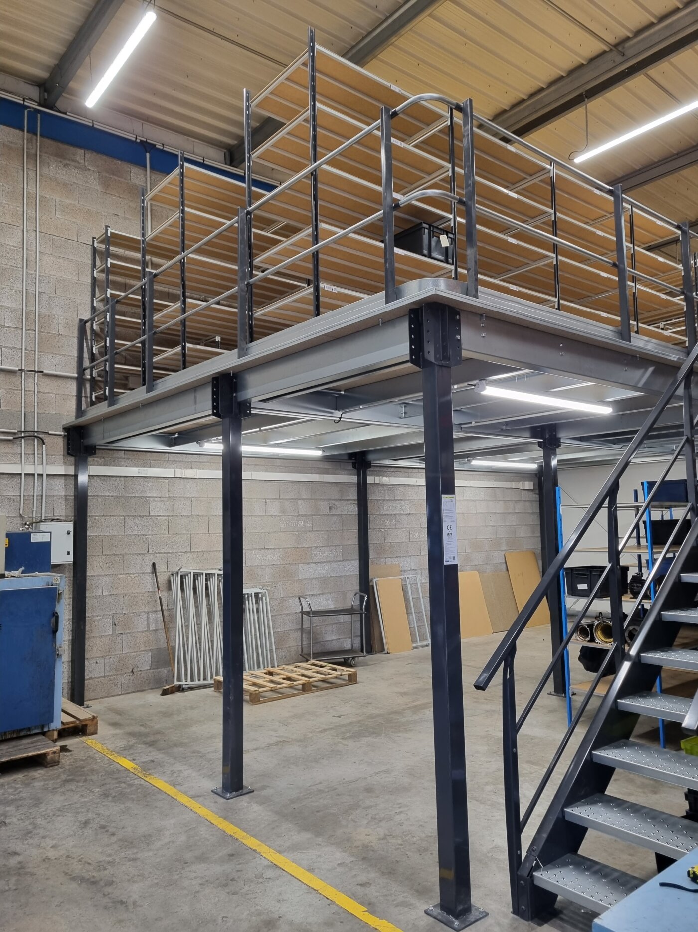 Découvrez nos mezzanines industrielles équipées de rayonnages, idéales pour augmenter votre capacité de stockage. Cette photo présente une réalisation récente de RSL, mettant en évidence la qualité de nos produits et notre savoir-faire en matière d'aménagement d'entrepôts.